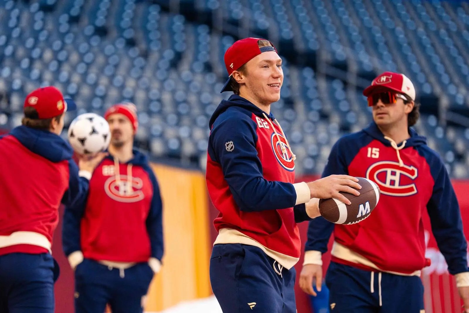 Owen Beck, ballon de football à la main, avec des coéquipiers du Canadien au Princess Auto Stadium