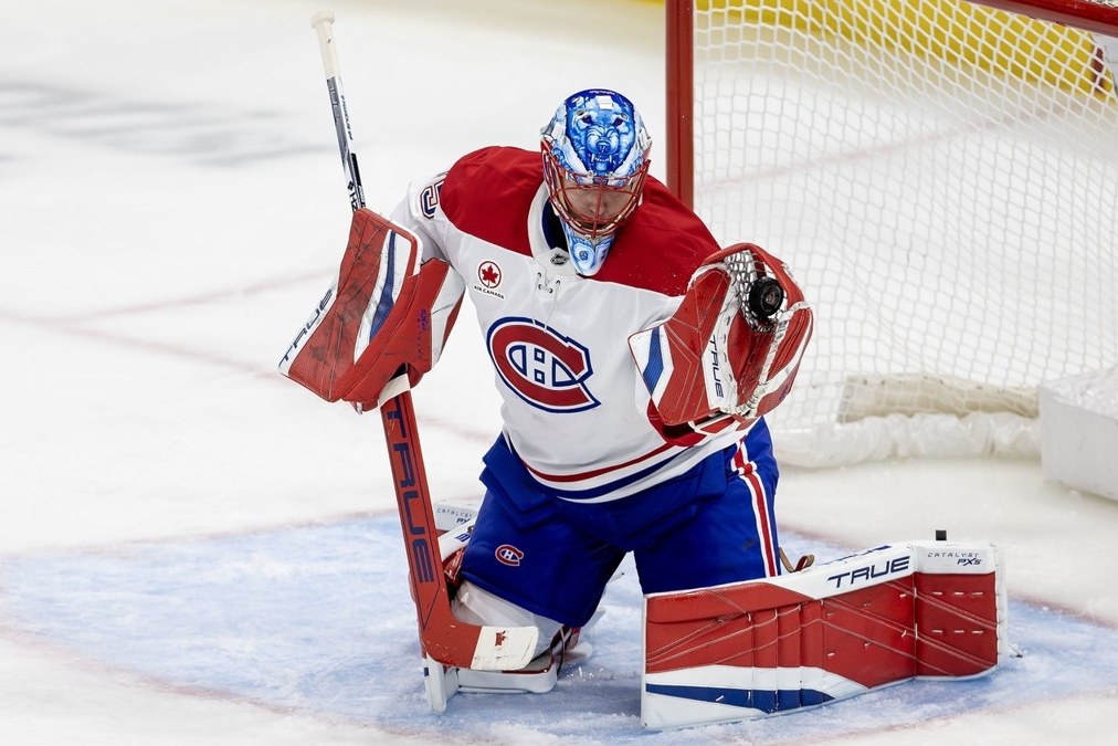 Jakub Dobes en position devant son filet, chandail blanc du Canadien