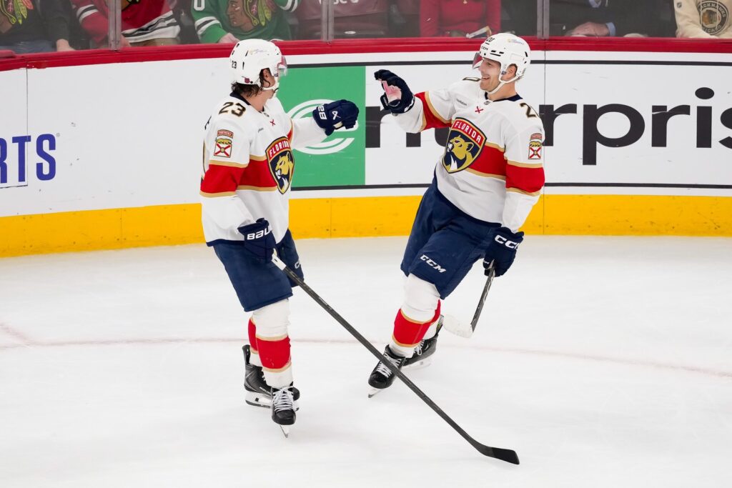 Lars Eller célèbre son premier but avec les Panthers en compagnie de Carter Verhaeghe, à Chicago (AP Photo/Harry Figiel)