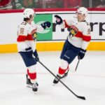 Lars Eller célèbre son premier but avec les Panthers en compagnie de Carter Verhaeghe, à Chicago (AP Photo/Harry Figiel)