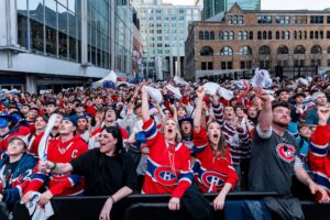 Des partisans du Canadien en chandails rouges célèbrent à l'extérieur