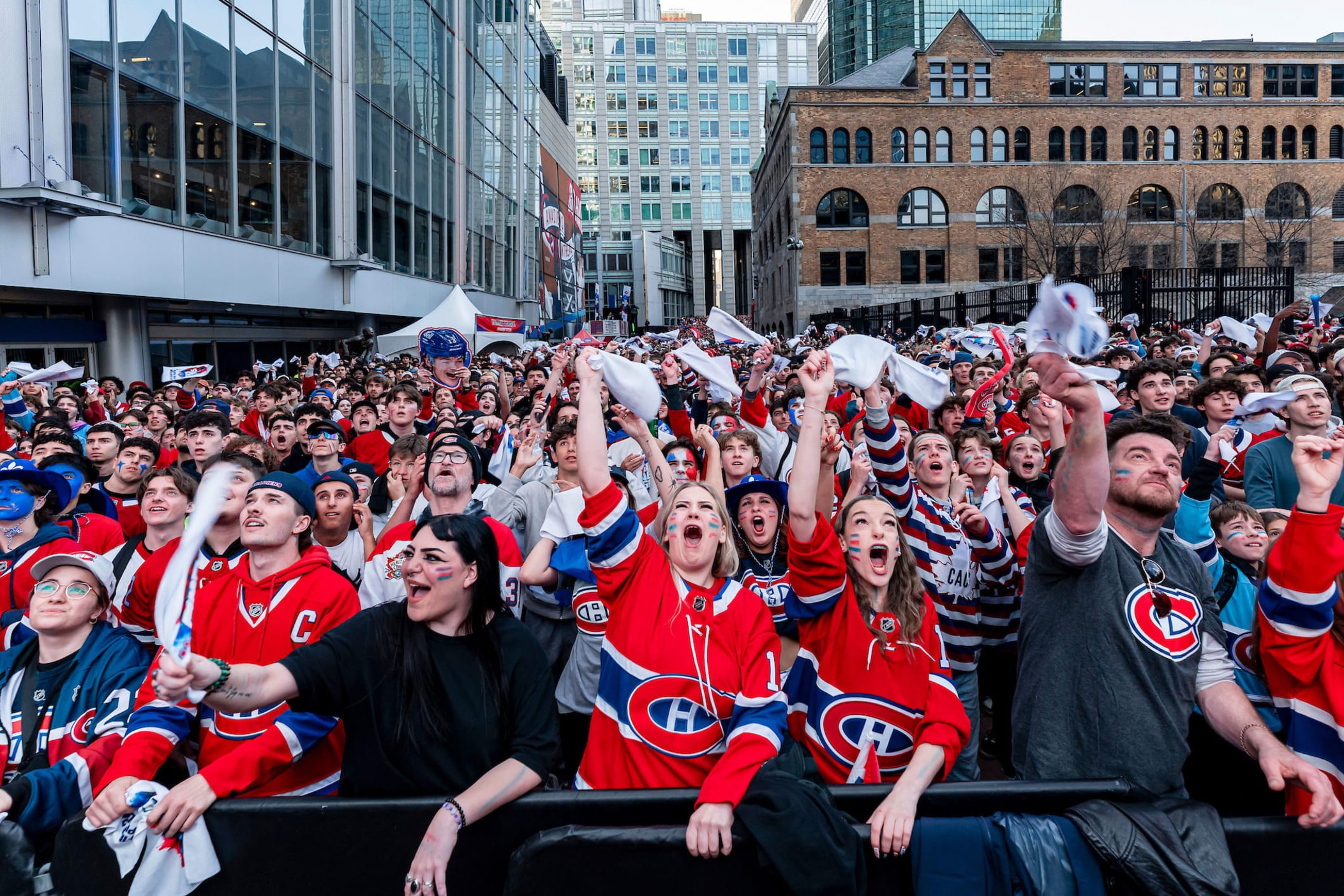 Des partisans du Canadien en chandails rouges célèbrent à l'extérieur