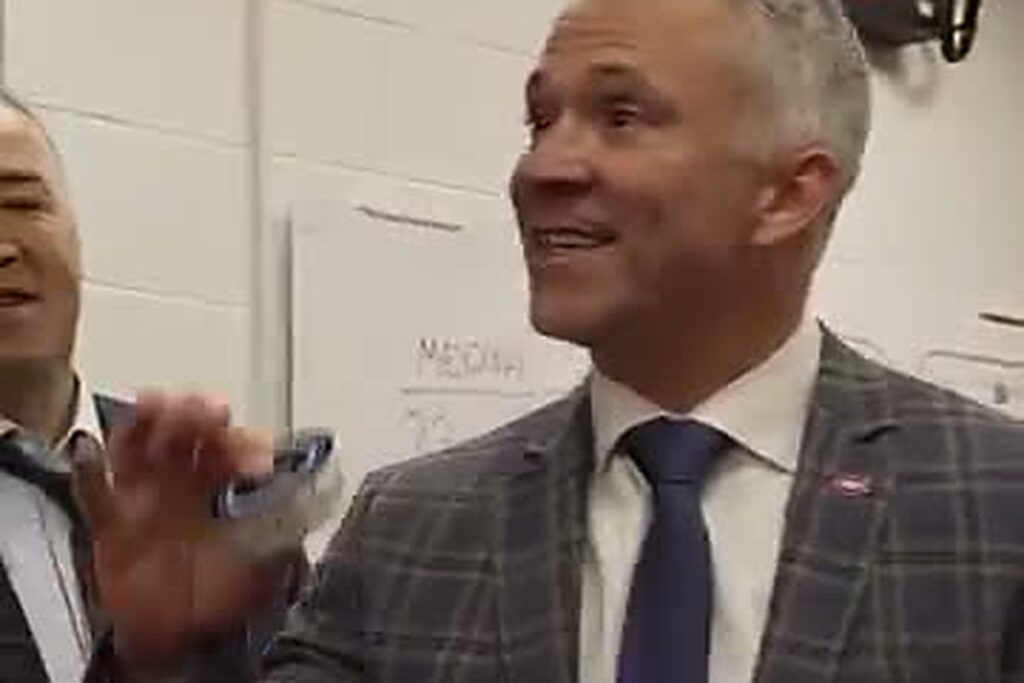 Martin St-Louis, tout sourire, une rondelle souvenir à la main dans le vestiaire du Canadien à St. Louis