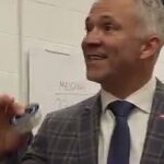 Martin St-Louis, tout sourire, une rondelle souvenir à la main dans le vestiaire du Canadien à St. Louis