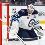 Connor Hellebuyck en chandail blanc des Jets de Winnipeg