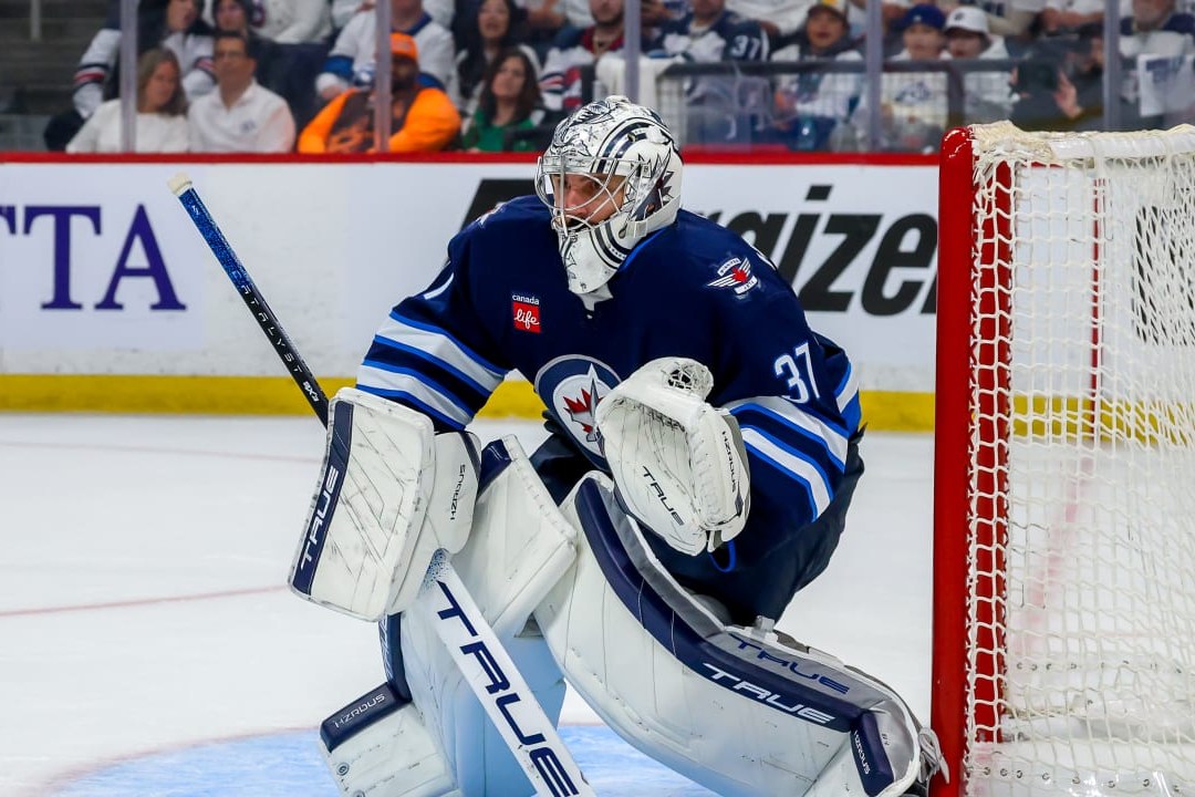 Connor Hellebuyck en chandail bleu des Jets devant son filet