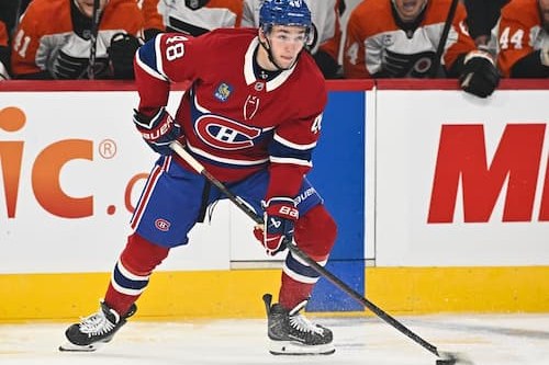 Lane Hutson, numéro 48 du Canadien, en chandail rouge, surveille le jeu devant les Flyers