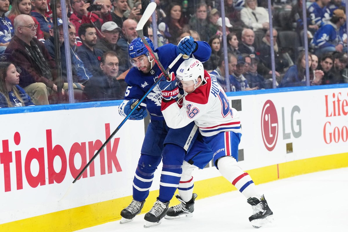 Lane Hutson en bataille le long de la bande, chandail blanc du Canadien