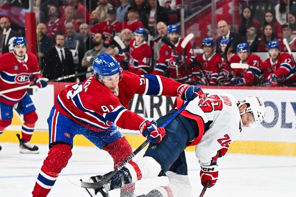 Oliver Kapanen, numéro 91 du Canadien de Montréal, en chandail rouge en bataille pour la rondelle