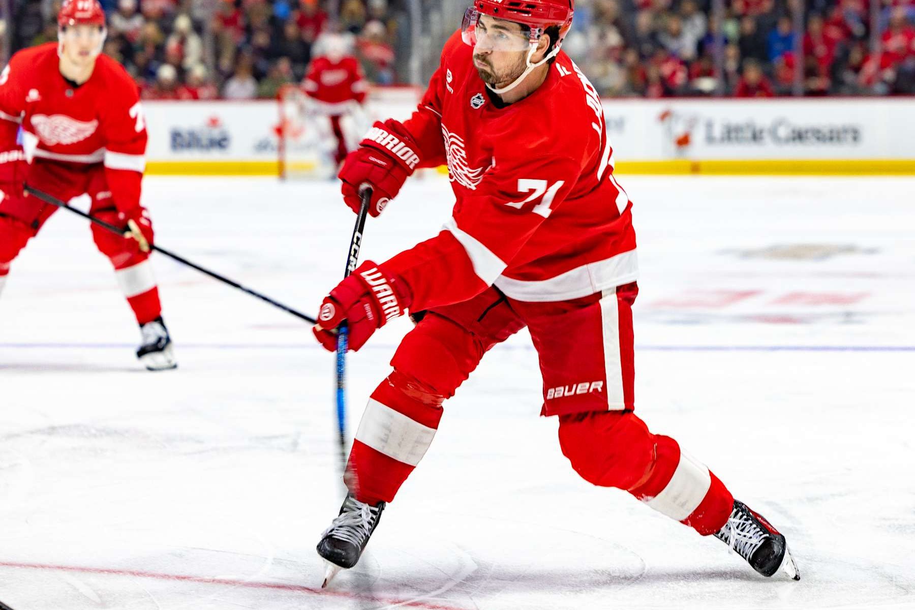 Dylan Larkin, numéro 71 des Red Wings de Detroit, en chandail rouge, s'apprête à tirer
