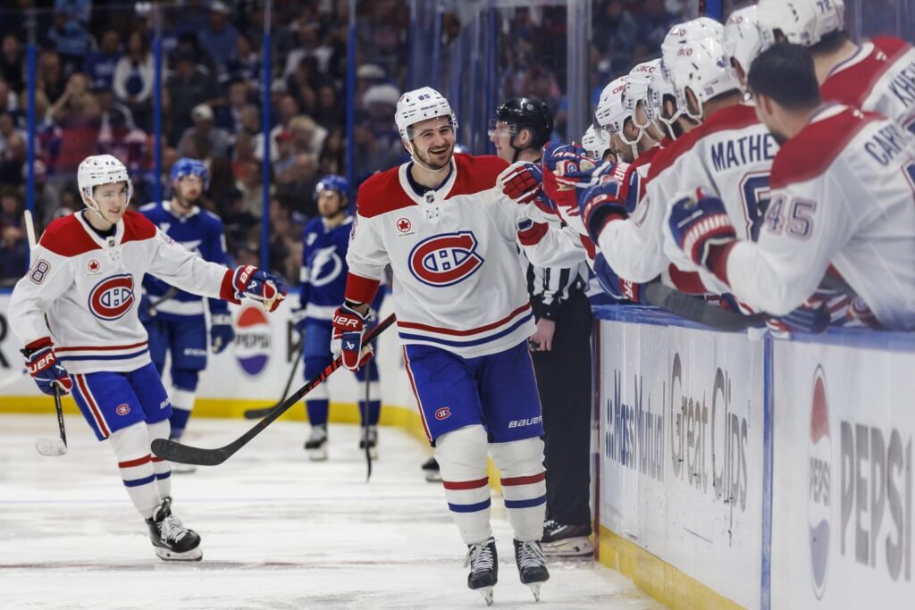 Les joueurs des Canadiens, en chandail blanc, célèbrent un but au banc de l'équipe sur la route